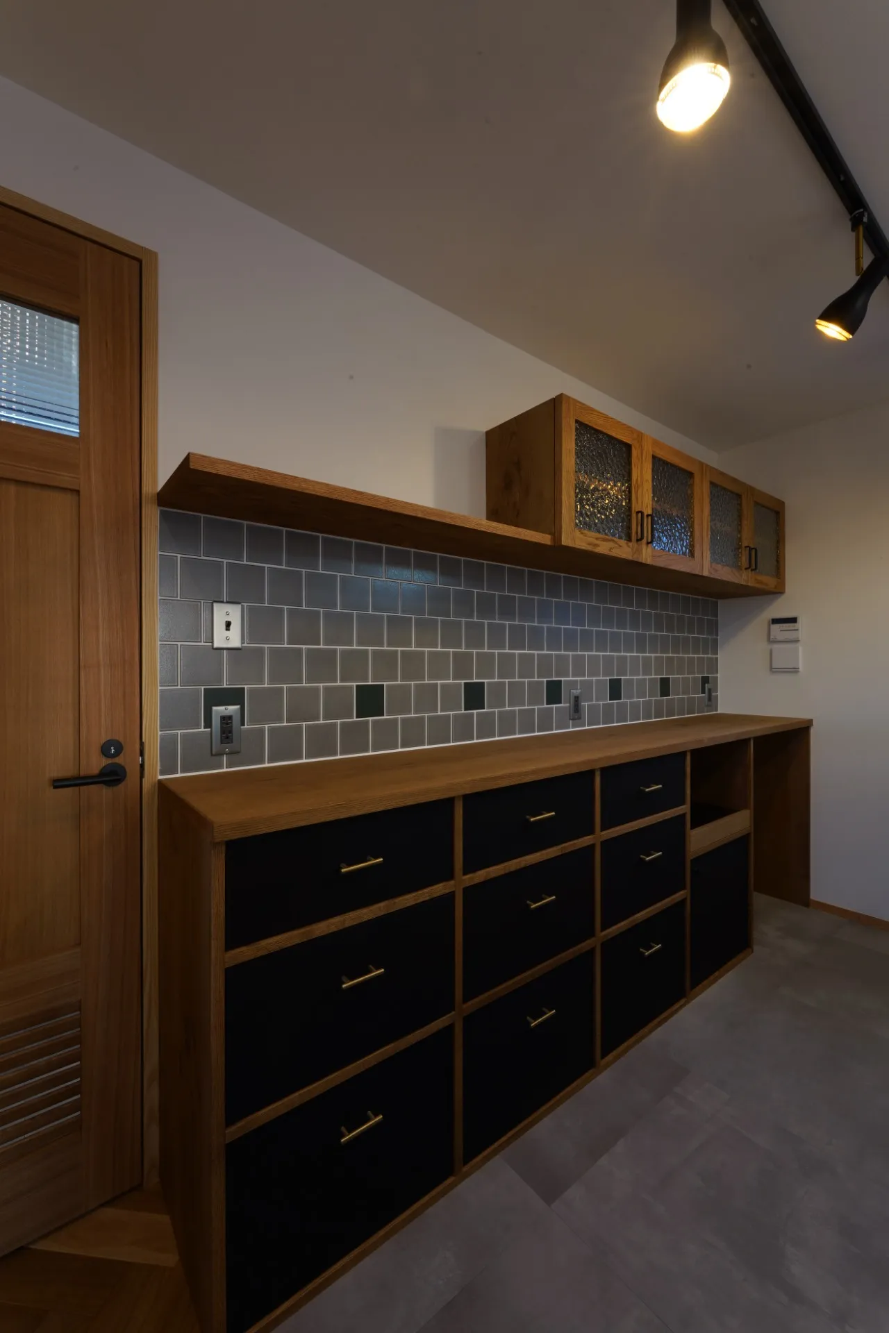 オークのフレームに黒で引き締めた引出。真鍮の取っ手とタイルがアクセントに。