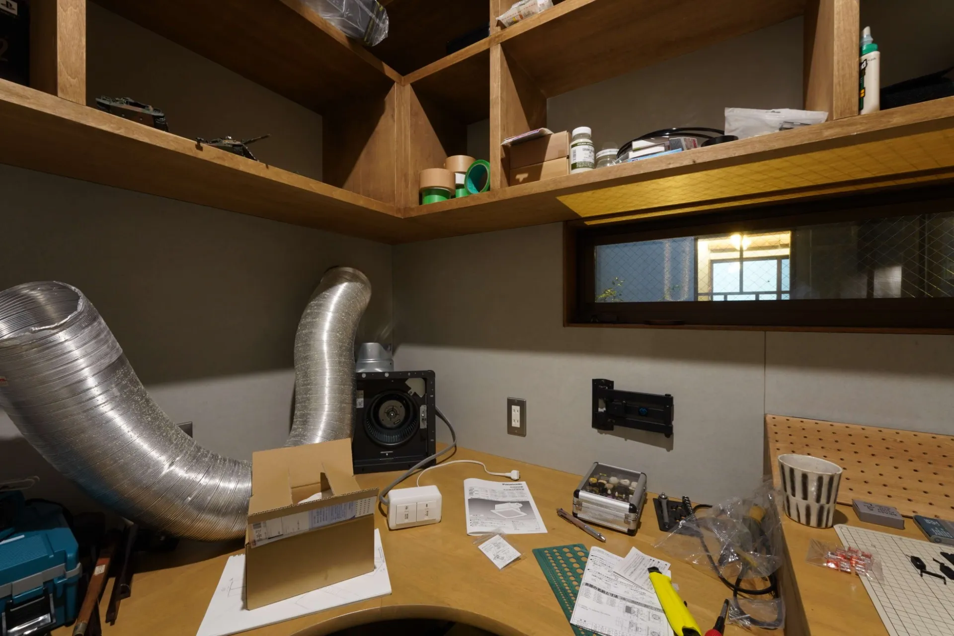 ご主人の趣味スペースである工作室は時計職人の机を参考にした工夫が。作業に集中しすぎないようにリビングから見えるステンドガラスの室内窓も。